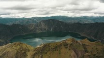 Aerial panorama view showing volcano landscape with calm blue colored crater lake in Andes	