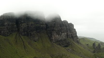 Scenic aerial view of Old Man of Storr mountain in Isle of Skye Scotland with misty atmospheric clouds