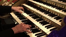 hands playing an organ 