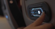 Woman using control pad of seat-back monitor in plane