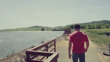 man walking around a lake shore 