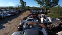 Aerial pullback of a junkyard with old cars