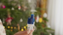A Young Girl Holds a Nebulizer Next to the Christmas Tree - Close Up