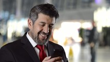 a man smiling checking his cellphone 