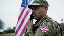 American Military Man Talks On The Phone With His Wife On The Base At War