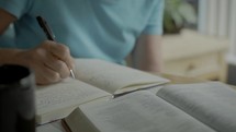 a woman reading a Bible and taking notes 
