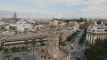 Half drone orbit around historic Torre del Oro watchtower, Seville, Spain
