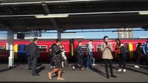 LONDON, UK - CIRCA SEPTEMBER 2019: Train passing at station with many travellers on the platform