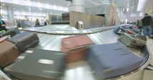 Passengers collecting luggage from a conveyor belt at the airport