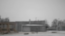 Snow falling on cold winter morning in small USA town in cinematic slow motion.
