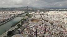 Maestranza bullring and sprawling Seville cityscape on cloudy day. Aerial view