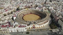 Descending drone view of iconic Maestranza bullfighting ring in Seville, Spain
