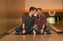 Couple sitting in a bowling alley lane