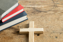 books and cross on a desk 