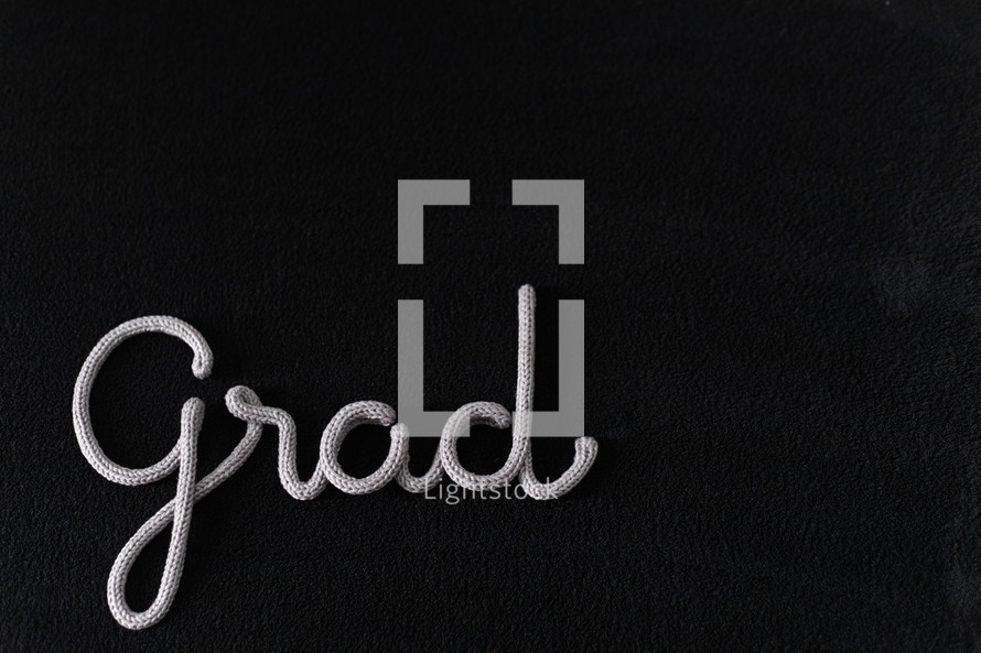 word grad in rope on a black background 