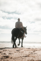 Horse riding on a beach, equestrian man riding on a horse