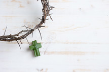 crown of thorns and palm cross on a white wood background 