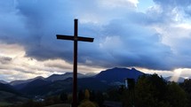 Timelapse of wooden cross on a rural landscape at dusk.
