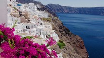 Famous whitewashed and colourful at the same time picturesque village of Oia built on a cliff, Santorini island, Cyclades, Greece