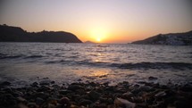 Ocean bay with sunrise, waves crashing slow motion Greece
