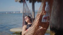 Peaceful  young woman relaxing in a hammock on vacation. 
