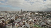 Drone flying over Plaza de Toros or bullring and Seville Cathedral in background, Spain. Aerial backward
