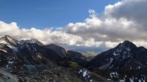 Alpine high mountain landscape. Blue sky and clouds. Panoramic shot, timelapse video.