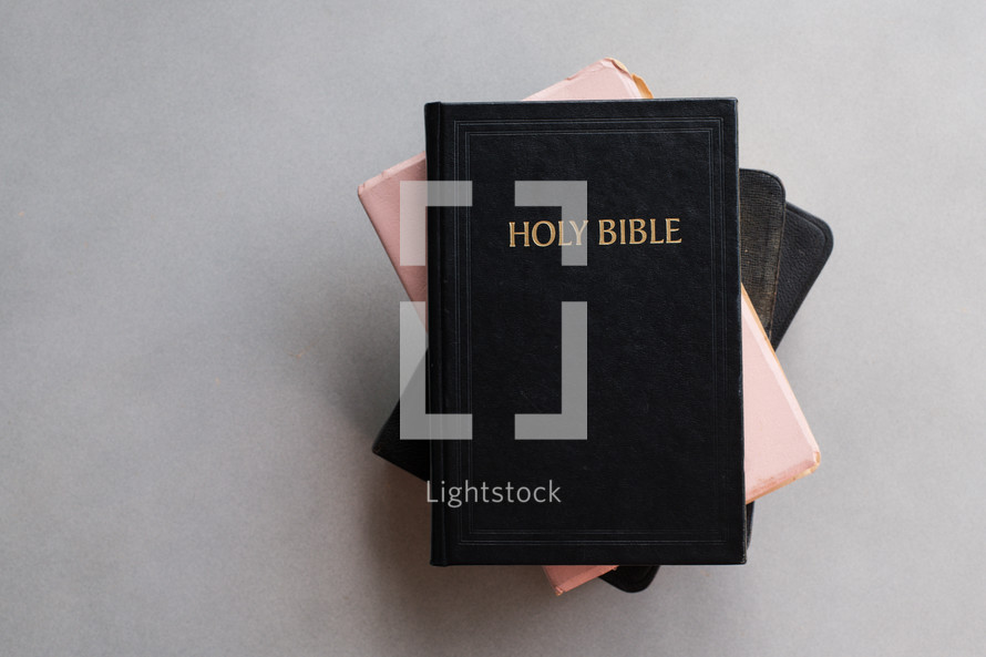 Holy Bibles stacked on a simple background with copy space