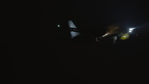 Commercial airplane flying at night low to the ground.