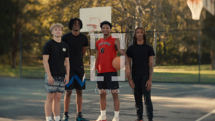 Portrait of smiling young men after playing basketball on a sunny day