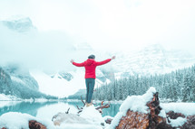 person standing on a snowy rock in front of Moraine Lake