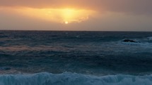 sun rises over the ocean waves