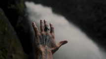 Male Hand With Tattoo Reaches Toward A Waterfall (Pailon del Diablo Waterfall, Baños de Agua Santa, Ecuador).