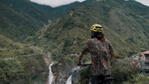 Biker looking to the waterfalls during biking route tour in Baños Ecuador