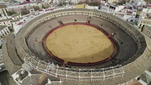Plaza de Toros or bullring and cityscape with cathedral in background, Seville in Spain. Aerial circling tilt up reveal 