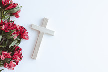 Wood cross with border of red flowers on a white background