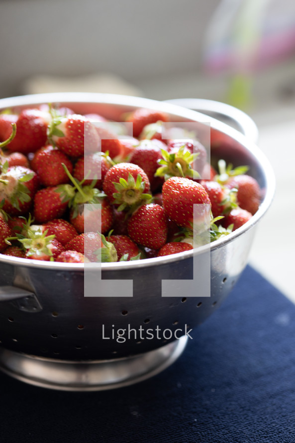 backlit strawberries in colander