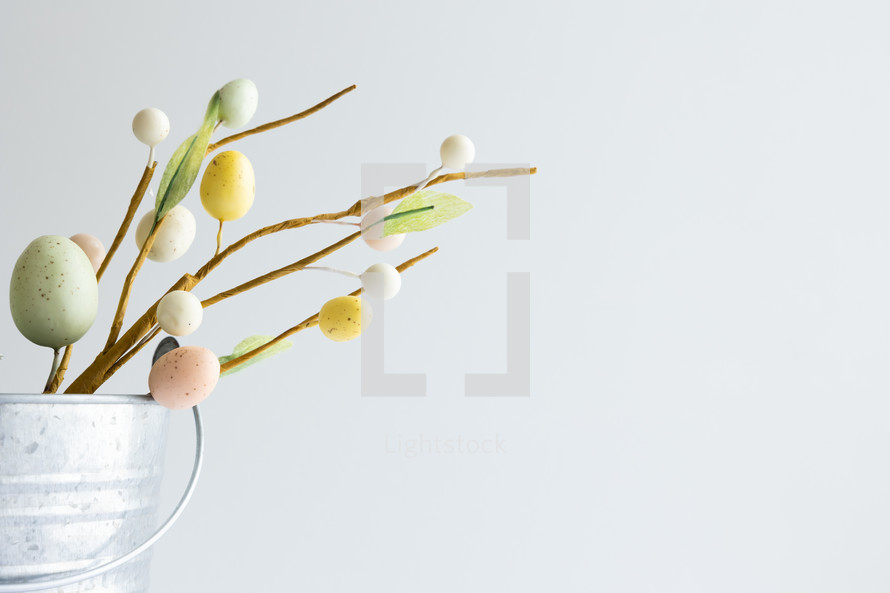 Easter eggs in silver bucket on white background