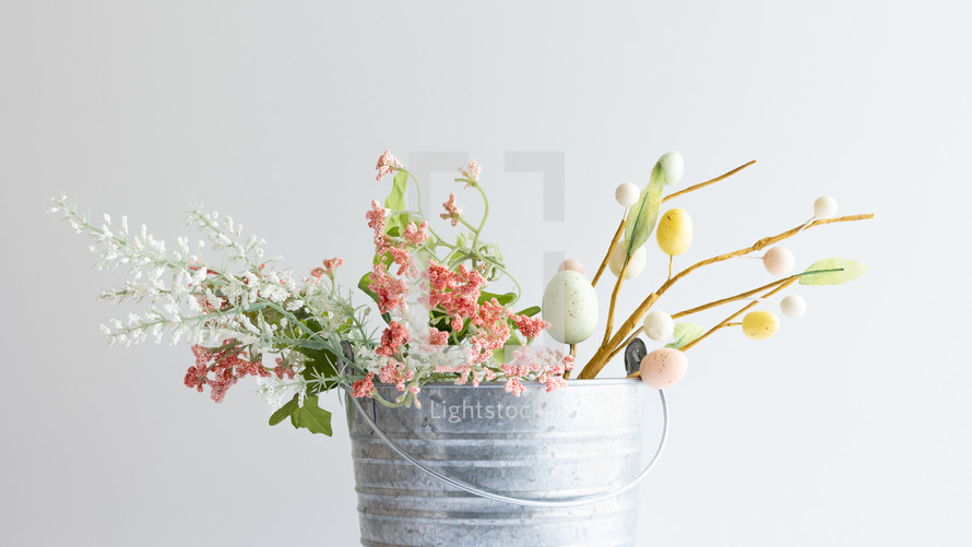 Spring flowers and easter eggs in silver bucket with copy space