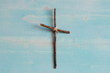 simple cross of sticks on a blue wood background 