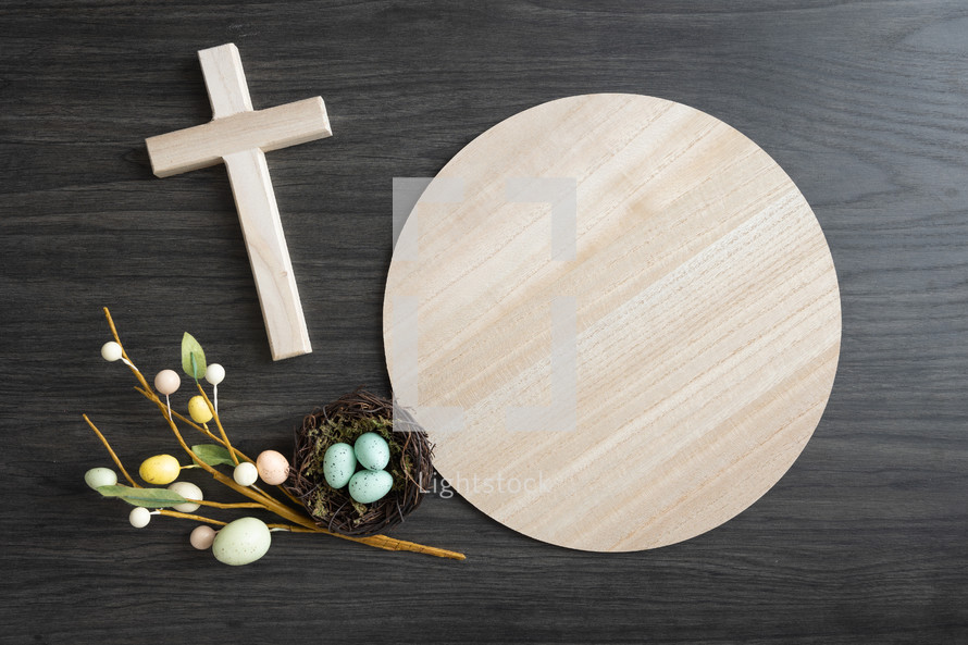 Round wood tray with small wood cross and easter eggs and nest