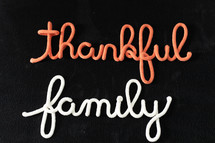 words thankful family in rope on a black background 