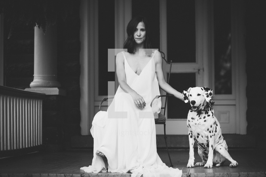 a woman sitting on a porch with her dalmatian 