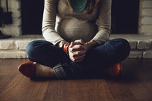a pregnant woman praying on the floor 