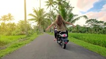 Woman riding scooter on tropical road with palm trees 4k

