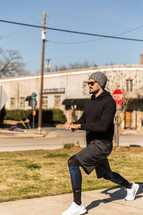 A man in workout clothes exercises outdoors.