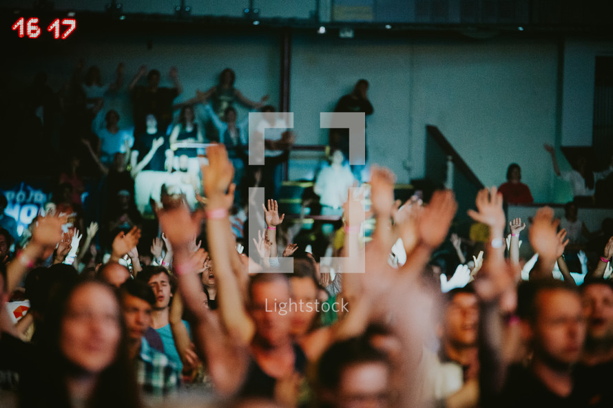 hands raised in worship at a concert in Prague 