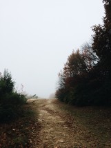 dirt road on a hill in fog 