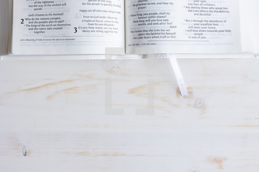 open Bible on a white wood background 