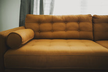 A gold upholstered couch.